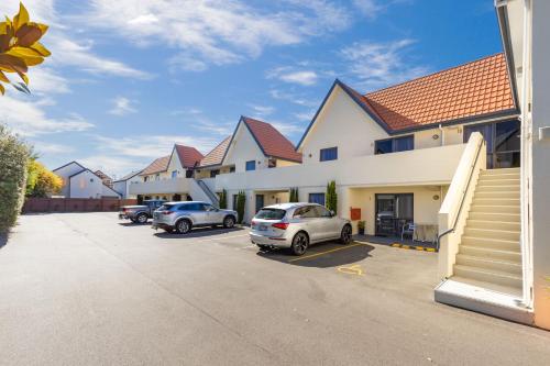 基督城Bella Vista Motel & Apartments Christchurch的停车场内一排有汽车的房屋