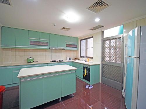 马公媽宮古街10號的厨房配有绿色橱柜和冰箱。
