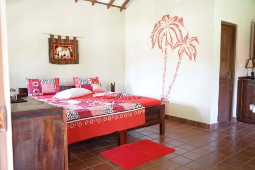 瓦伊卡尔普兹崔维海滩度假酒店的卧室配有一张床铺,墙上挂着棕榈树