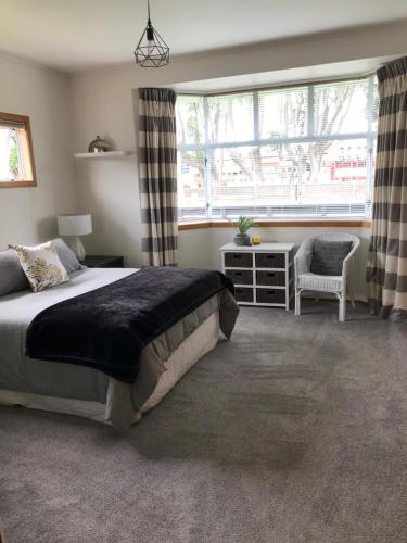 新普利茅斯Fitzroy Gem的卧室配有床、椅子和窗户。