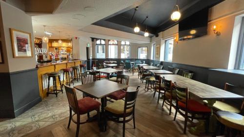 曼彻斯特Piccadilly Central的一间带桌椅的餐厅和一间酒吧
