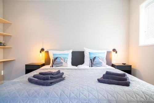 佐特兰德Vrijstaande vakantiewoning - Dicht bij het Strand的一间卧室配有一张带紫色毛巾的床