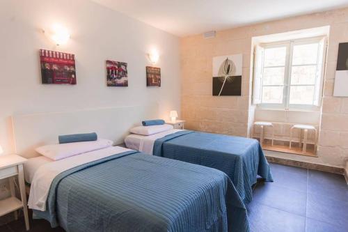 弗洛里亚纳Central Valletta house的客房设有两张床和窗户。