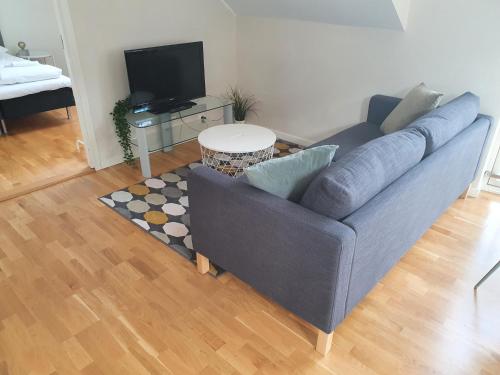卑尔根Veversmauet Apartments的客厅配有蓝色的沙发和桌子