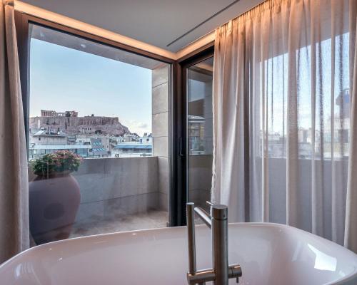 雅典Niche Hotel Athens的带浴缸的浴室和窗户