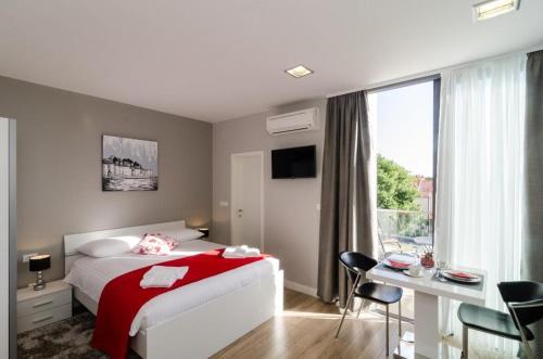 杜布罗夫尼克兹奥姆兹奥姆公寓的一间卧室配有一张床、一张书桌和一个窗户。
