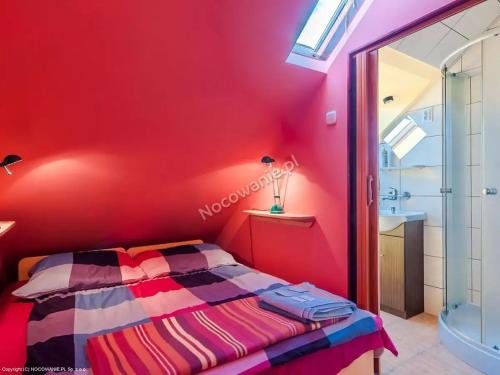 格但斯克POKOJE GOŚCINNE SURFINIA的卧室设有红色墙壁、一张床和一个水槽