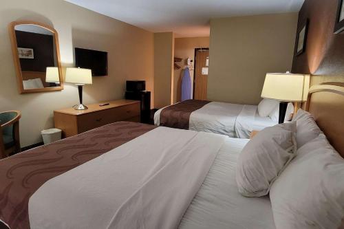 法戈Travelodge by Wyndham Fargo的酒店客房设有两张床和电视。