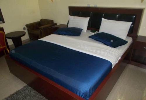 阿沙巴Room in Lodge - Dublina Hotels and Suites的床上有2个蓝色枕头