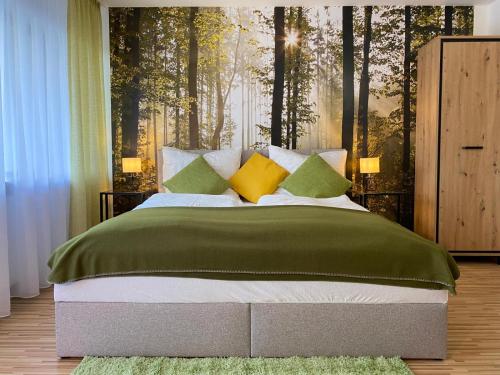 巴登-巴登Wanderlust Apartment Baden-Baden的一间卧室配有一张带绿色和黄色枕头的大床