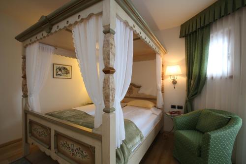 阿拉巴Hotel Mesdi的一间卧室配有四柱床和椅子