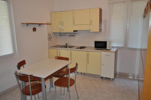 莱圭利亚帕拉迪索公寓式酒店的厨房配有桌椅和微波炉。