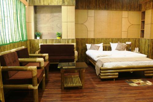 阿加尔塔拉Hotel Himalaya的一间卧室配有一张床、一张沙发和一把椅子