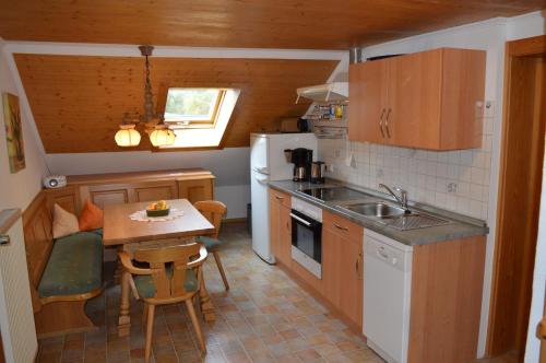 贝希特斯加登Ferienwohnungen Kilianmühle的厨房配有水槽和桌椅