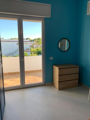普尔萨诺Appartamento Cielo的一间拥有蓝色墙壁和滑动玻璃门的客房