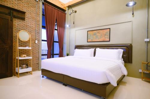 乌隆他尼Dream Factory Hotel的卧室设有一张白色大床和一扇窗户。