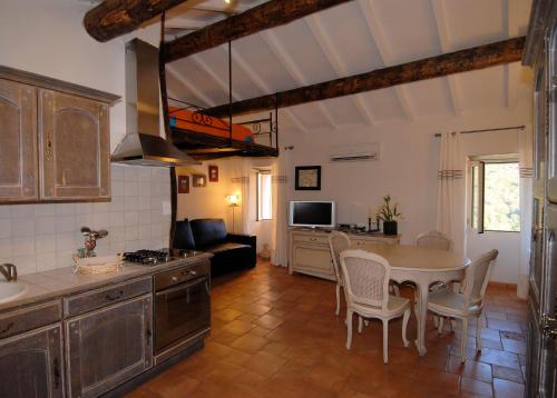 尔萨Latu Corsu - Côté Corse - Gites et chambres d'hôtes au Cap Corse的厨房以及带桌椅的起居室。