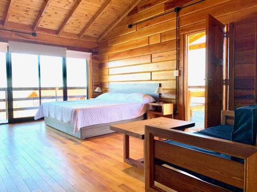 坎伯雷塔Alma Serrana - Suites de montaña!的木制客房内的一间卧室,配有一张床