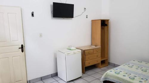 帕林廷斯Suítes em Parintins的一间小房间,配有冰箱和墙上的电视