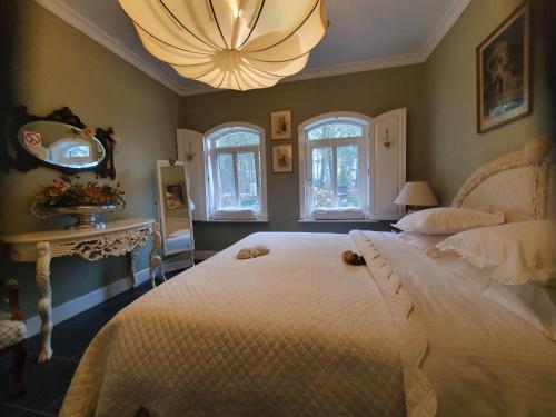 Sterkselde Loverlei的卧室配有一张白色大床和吊灯。