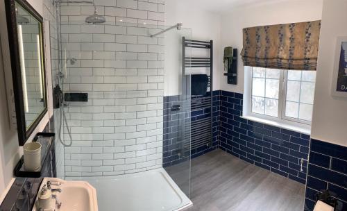 埃克塞特Seven Stars Boutique Guesthouse的浴室设有水槽和蓝色瓷砖淋浴。