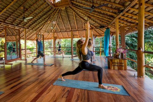 乌维塔Selva Armonia Immersive Jungle Resort的在一个凉亭里参加瑜伽课的女人