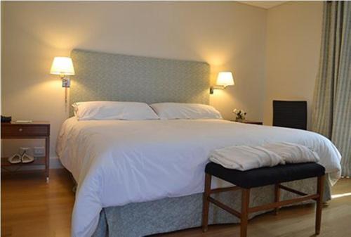 门多萨Hotel Finca Hermitage的一间卧室配有一张带两盏灯的大型白色床。