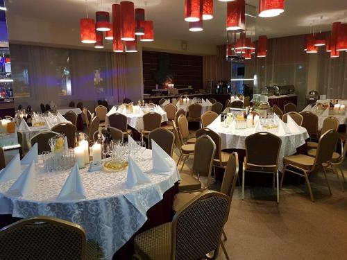 德鲁斯基宁凯代纳瓦酒店的一间设有白色桌椅的用餐室