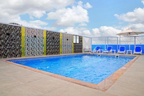 阿吉曼Alain Hotel Ajman的一个带椅子和遮阳伞的游泳池