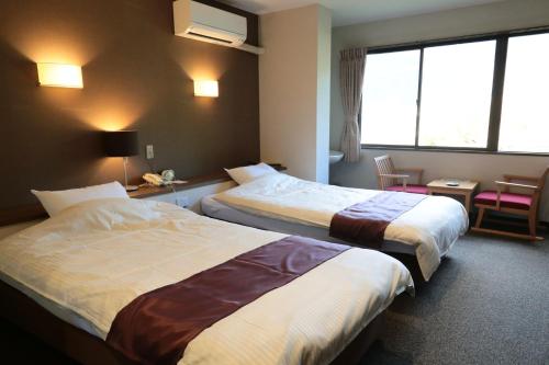 熊野市清流庄海豚温泉酒店的酒店客房设有两张床和窗户。