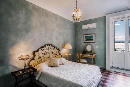 锡拉库扎Dimora di Ulisse Sea View Holiday Apartment的一间卧室设有一张床和一个大窗户