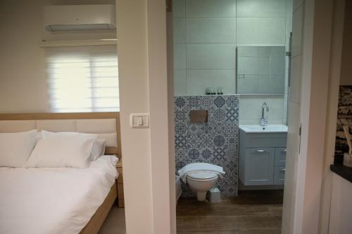迈季代勒舍姆斯Adan - Suietes的一间卧室配有床、水槽和卫生间