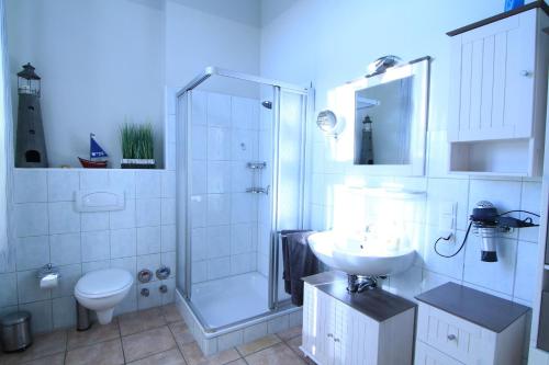 格洛韦F-1063 Stachelbeerbluete in Glowe的带淋浴、卫生间和盥洗盆的浴室