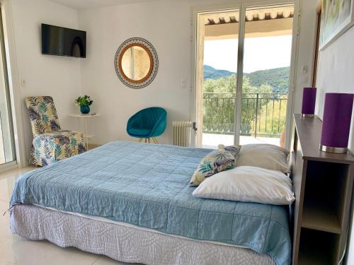 阿盖大湾别墅的一间卧室设有蓝色的床和一个阳台