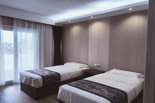 托里代巴拉Hotel Nueva Europa的酒店客房设有两张床和窗户。