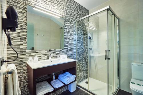 罗列特海岸Hotel Julimar的一间带水槽和玻璃淋浴的浴室