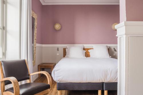 比亚里茨圣朱利安酒店的一间卧室配有一张床和一把椅子
