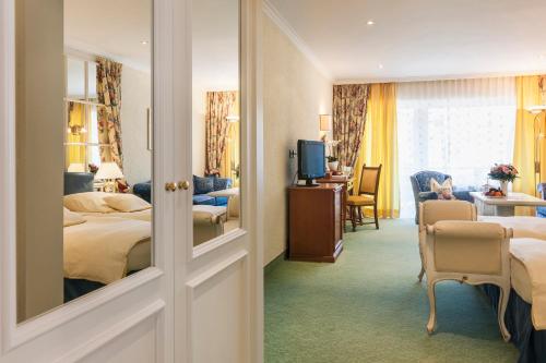 巴登韦勒Relais & Châteaux Hotel Schwarzmatt的酒店客房带两张床和一个客厅