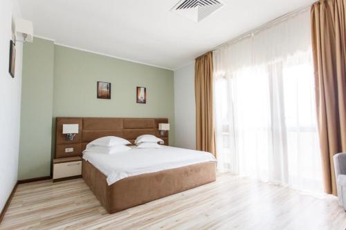 北马马亚-讷沃达里航海运动俱乐部酒店的一间卧室设有一张大床和一个大窗户