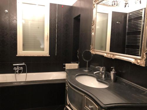 陶尔米纳Taonasi Taormina Apartments的浴室配有盥洗盆、镜子和浴缸