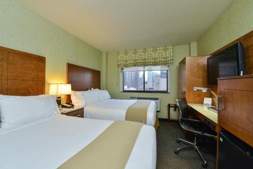 纽约曼哈顿西城智选假日酒店的酒店客房设有两张床、一张桌子和一台电视。