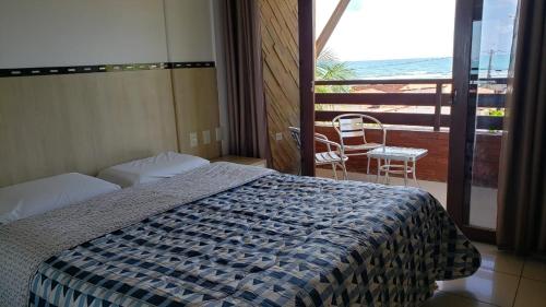 皮帕Pipas Ocean Prime Vista Mar的一间卧室配有一张床,阳台配有椅子