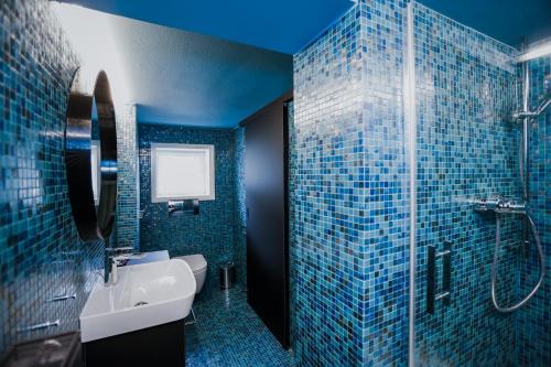 霍恩埃姆斯HEINRICH Stadtwohnung im Jüdischen Viertel的蓝色的浴室设有水槽和淋浴