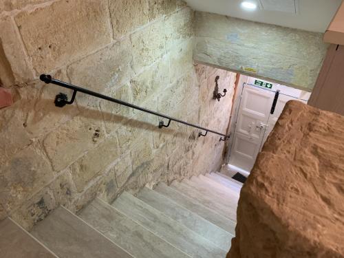 瓦莱塔Charming house in the heart of Valletta CPAC1-3的石墙和白色门的楼梯