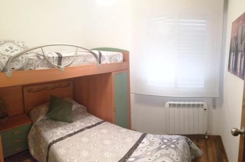 奥伦塞Enseñanza的一间小卧室,配有一张双层床和绿色枕头