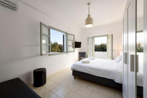 帕罗斯岛Strata Home by Rocks Estates的一间白色卧室,配有床和2个窗户