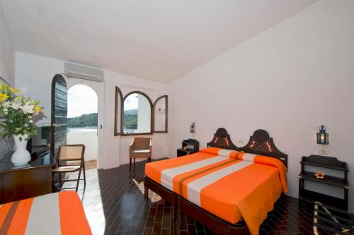阿祖罗港卡拉迪莫拉酒店的卧室配有一张床和一张桌子及椅子