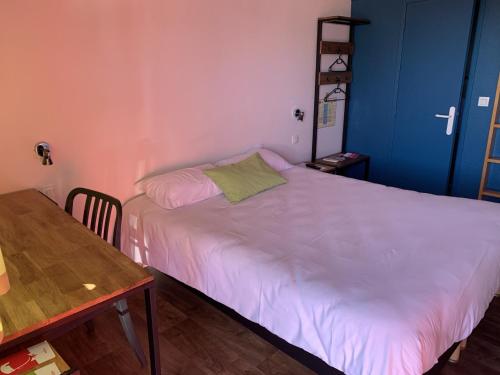 奥尔瓦勒Fasthotel Saint-Amand-Montrond Orval的一间小卧室,配有白色的床和一张桌子