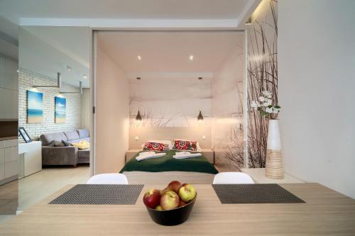 尤斯托尼莫斯基纳克利夫耶公寓的一间卧室配有一张床,桌上放了一碗苹果