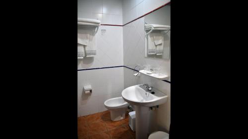卢耶哥索摩查Casa Rural Molino Del Arriero的白色的浴室设有水槽和卫生间。